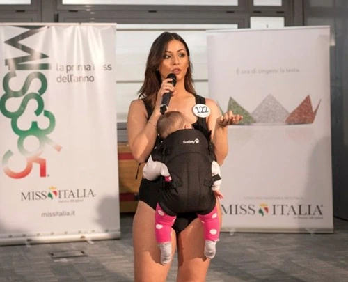 Miss Italia candidata insultata sul web perché sfila con la figlia nel marsupio
