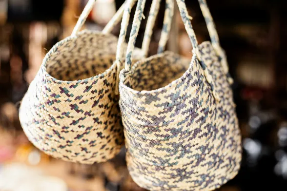 Borse in raffia. https://unsplash.com/it/foto/un-paio-di-cesti-appesi-al-soffitto-5dEiy7xiozM